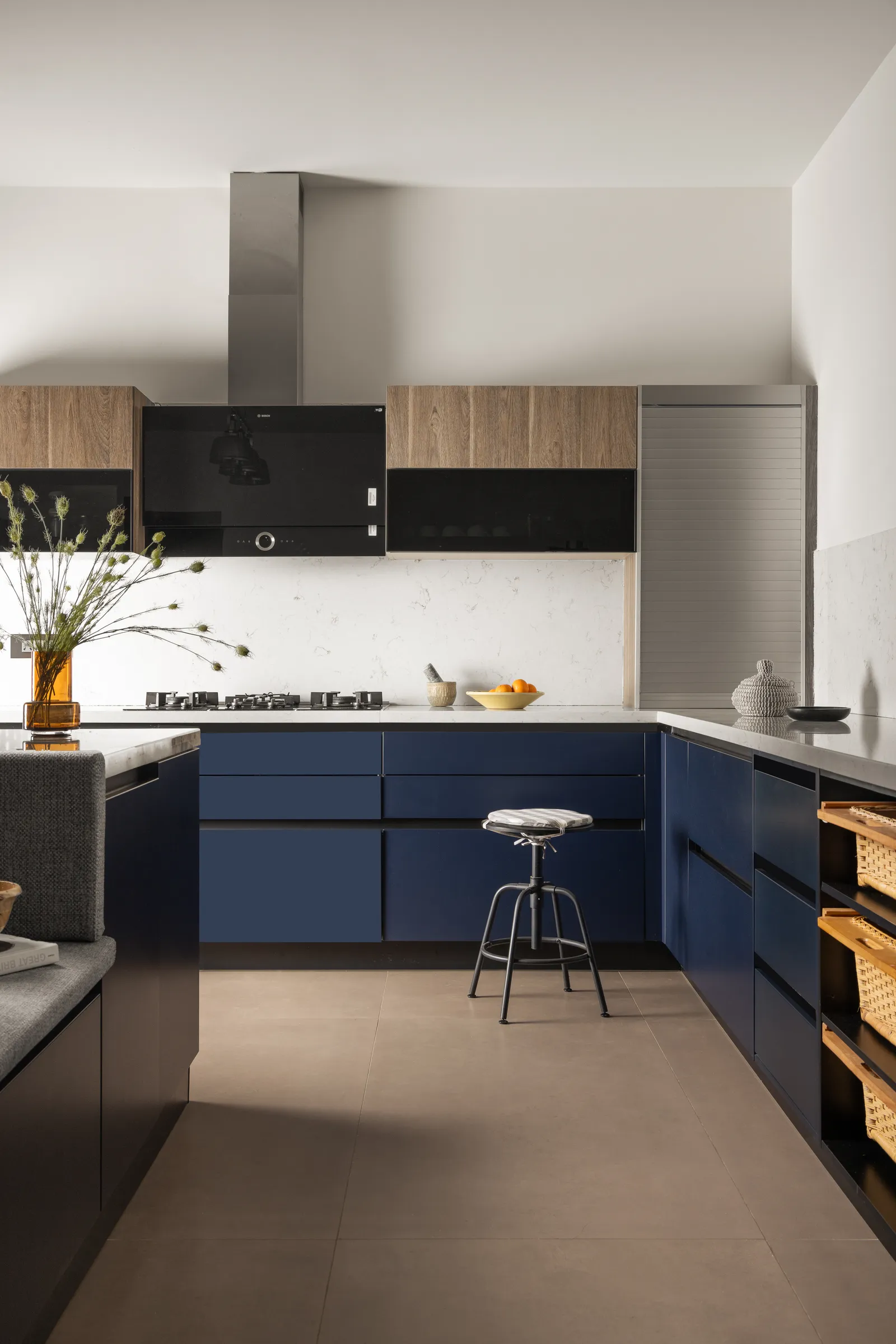 Kitchen with navy base cabinets and stainless chimney — Seema Katta Svasa